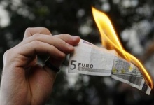 A demonstrator 
burns a five euro note during a protest in downtown Madrid against 
capitalism and the G20 Summit on Financial Markets and the World Economy
 November 15, 2008. REUTERS/Susana Vera 